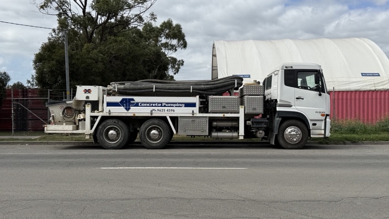A.F. Concrete Pumping line pump truck, side view, in the shed