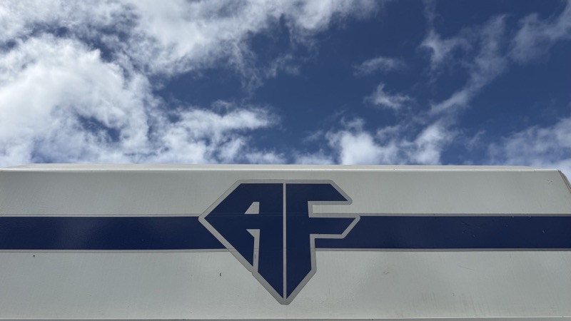 The A.F. Concrete Pumping sign against a blue sky