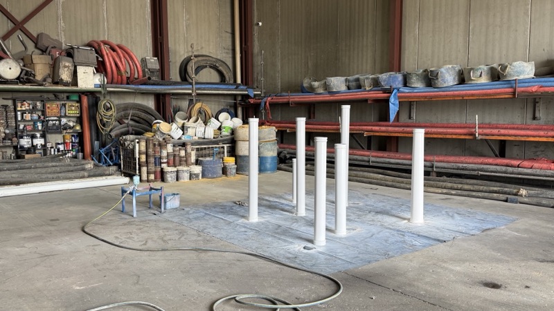 Lengths of delivery pipe standing on the workshop floor